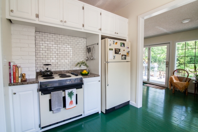 Green floors and white subway tile in bright kitchen